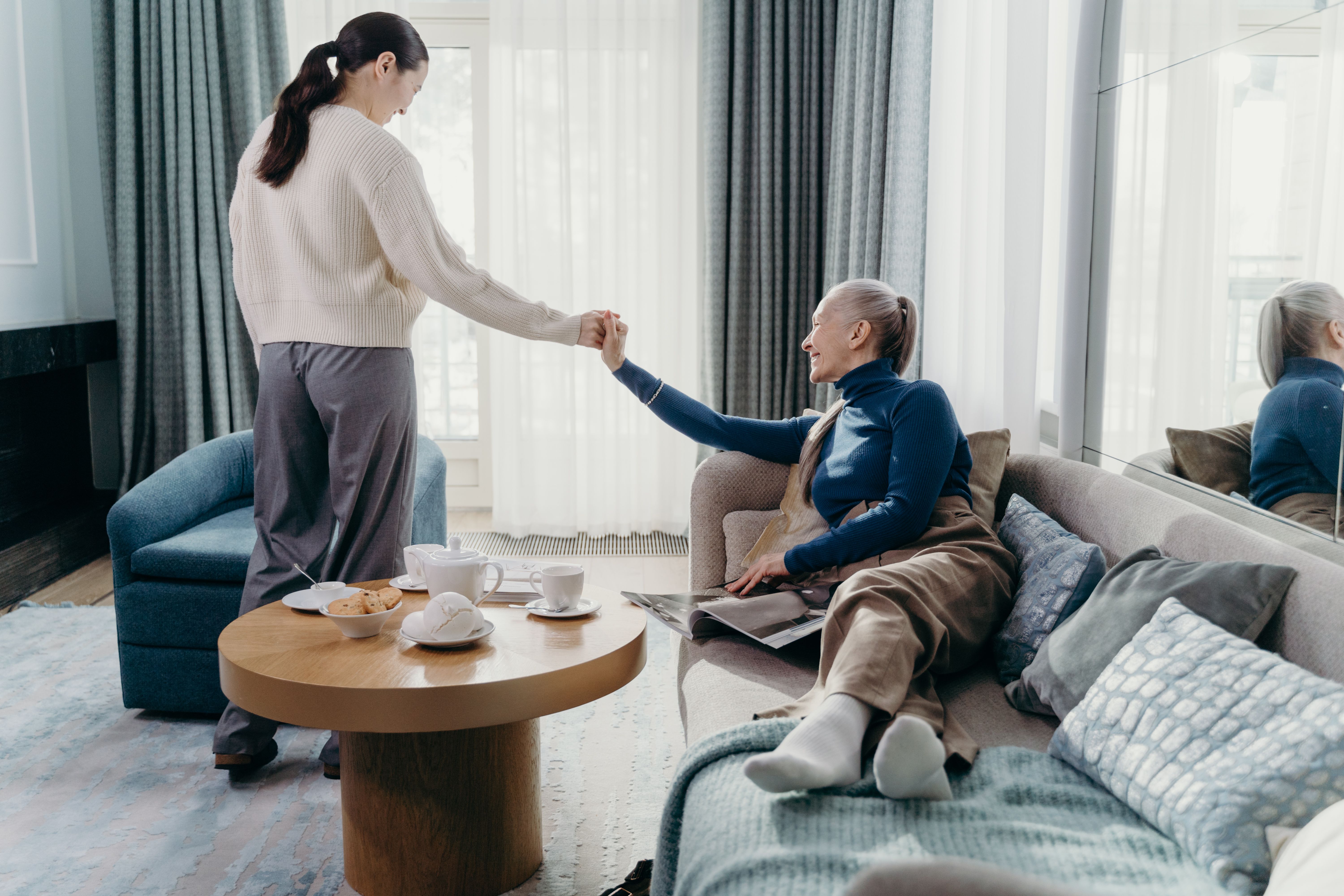 Adult caregiver offering support to an older woman at home